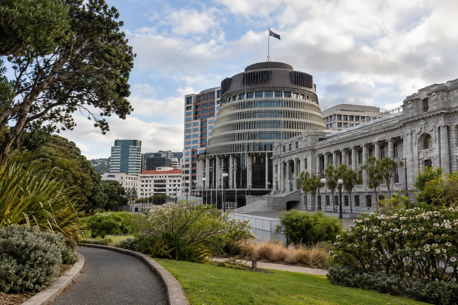 Wellington parliament grounds seen from a side path, planting beds and the civic complex beyond, no people